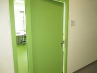 Eine hellgrüne Tür in einer hellen Wand