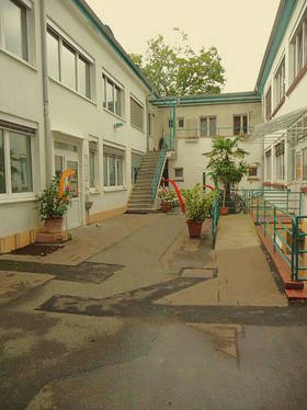 Hinterhof, Gebäude in U-Form. Linker und rechter Gebäudetrakt: Eingang zum EG, Zugang zu Eingängen im 1. OG über Treppe; am linken Gebäudetrakt angebaut