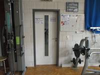 helle Tür mit dunklem Rahmen, rechts und links Sportgeräte
