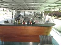 Bar aus Holz, hinter der Bar stehen Gläser und Flaschen