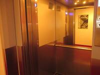 Ein offener Aufzug mit einem Spiegel und einem Handlauf an der hinteren Wand
