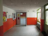 Tür mit einem offenen Flügel, rechts eine Glasfront, links eine Wand, im unteren Teil orangen gestrichen. 