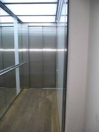 ab Passage: offenstehende Aufzugstür, Innenkabine mit Handlauf und Spiegel