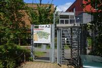 Von Zoogelände aus: Drekhreuztür, links daneben Metallgittertür mit großen Zooplan und Beschriftung "Tor A2 - hier kein Ausgang"