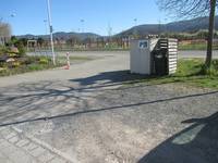Groß angelegter Behindertenparkplatz der teilweise auf Kies ist und teilweise auf Pflastersteinen ist. 