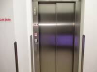 Ein Aufzug aus Edelstahl in einer hellen Wand.