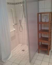 Dusche mit Duschvorhang, Seitenbegrenzung und Duscharmatur 